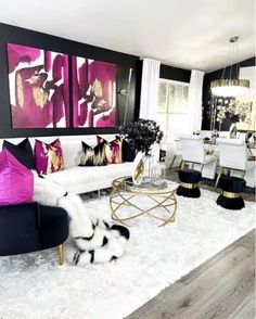 the living room is decorated in black and white with pops of pink on the walls