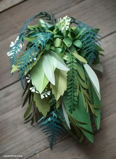 a bunch of green leaves on top of a wooden floor