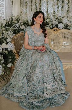 a woman sitting on top of a chair in a blue dress