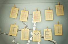 several pieces of paper hanging from clothes pins on a tree branch with the word time written on them