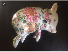 a ceramic pig figurine with flowers painted on it