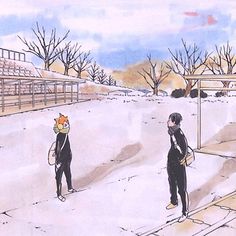 two people in wetsuits standing on the side of a snow covered tennis court