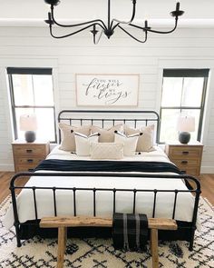 a bedroom with white walls and black iron bed frame