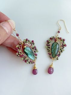 Discover the perfect gift for her with these stunning handmade unique earrings. Featuring a flashy beautiful Labradorite framed with beautiful ruby, pyrite and peridot. These statement earrings are a unique addition to any ensemble.   Each pair is meticulously crafted to create a one-of-a-kind (OOAK) piece that captures the essence of elegance and antique charm.  Every parts including ear wires are handmade by me. Material Flashy Labradorite  Ruby Peridot Pyrite  Tarnish resistant wire Total length : 3 1/2 inches or 9cm WANT MORE?  ENTER MY SHOP https://www.etsy.com/shop/SweetStoneLove  SHIPPING  The processing time for most orders is 1-2 business days.   Enjoy free US standard shipping on orders of US $35 or more Follow me on Instagram for updates, special offers, and behind-the-scenes ph Handmade Green Tourmaline Earrings, Handmade Tourmaline Green Earrings, Perfect Gift For Her, Unique Earrings, Precious Metals, Gemstone Earrings, Jewelry Care, Statement Earrings, Jewelry Art