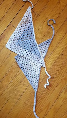 a white crocheted kite laying on top of a wooden floor