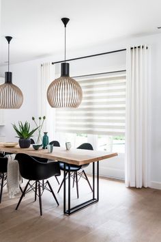 a dining room table and chairs in front of a window