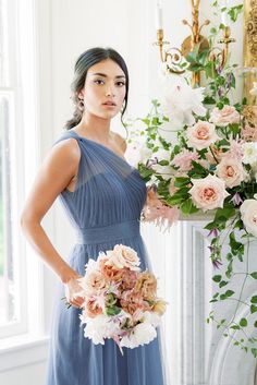 a woman in a blue dress holding a bouquet