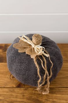 a gray hat with a burlock on it sitting on top of a wooden floor