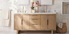 a bathroom vanity with two mirrors and flowers on the counter top, along with other accessories