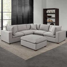 a living room with a sectional couch and ottoman