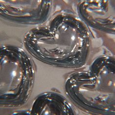 an image of some heart shaped objects in the water or ice cubes that are floating on top of each other