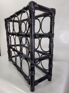 a black metal rack sitting on top of a white surface