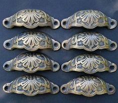 six antique brass drawer pulls with ornate designs