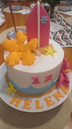 there is a cake that has been decorated with flowers and surfboards on top of it