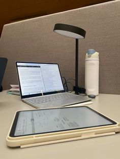 an open laptop computer sitting on top of a desk next to a smart phone and tablet