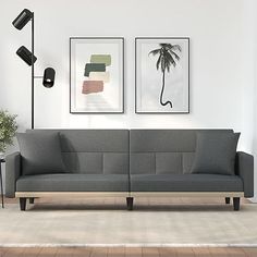 a living room with two pictures on the wall and a couch in front of it