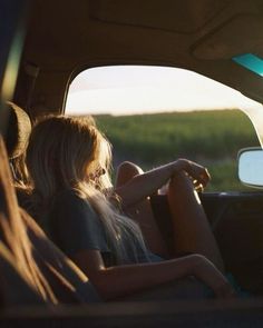 two people are sitting in the back seat of a car, looking out the window