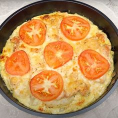 a pizza in a pan with tomatoes on top