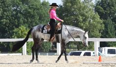 a woman riding on the back of a white horse