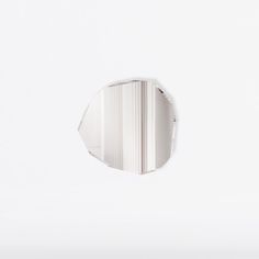 a white wall with a round mirror on it