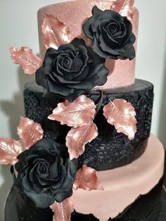 a black and pink wedding cake with roses on top