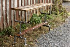 an old wooden bench with pipes attached to it