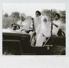 three men in turbans are riding on a tractor