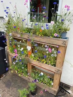 a wooden planter filled with lots of flowers