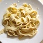 a white plate topped with pasta covered in sauce