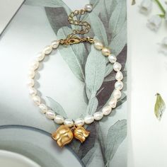 This Lily Of The Valley Pearl Bracelet is a luxurious gift for any special occasion. The timeless design of this exquisite accessory is perfect for any woman's personal style and features beautiful blooms of lily of the valley. A gift of extraordinary elegance, it will be sure to make the recipient feel celebrated and cherished on their special day.  DETAILS Materials:   18K Gold on Brass, Freshwater Pearl Measurements: Length: 17.83"(45.3cm) + Extender: 1.97"(5.0cm) Weight:   5.4 g Choose a lil Elegant Adjustable Gold Bracelet For Mother's Day, Elegant White Bracelets With Flower Charm, Elegant Gold Bracelet With Flower Charm, Elegant Rose Gold Bracelets With Flower Charm, Elegant Gold Plated Charm Bracelet For Gifts, Elegant Rose Gold Bracelet With Flower Charm, Elegant Gold Beaded Bracelet With Flower Charm, Elegant Rose Gold Bracelets As Gift, Elegant Flower Charm Bracelet Gift