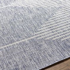 a blue and white rug on top of a wooden floor