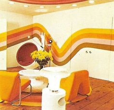 a dining room with yellow chairs and a white table in front of a colorful wall