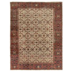 an antique rug with red and beige colors