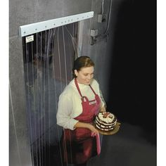 a woman in an apron holding a cake