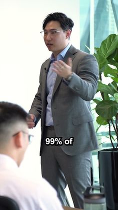 a man in a suit is giving a presentation