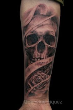 a man's arm with a skull and rose tattoo on it