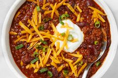 a white bowl filled with chili and cheese