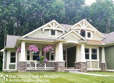 the front view of a house with flowers on the porch and windows in the back