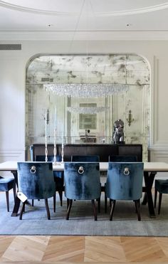 a dining room table with blue chairs and a chandelier