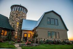 a large house with a tower in the middle of it's front yard at sunset