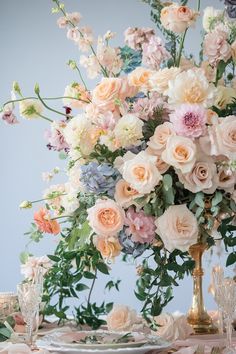 a vase filled with lots of flowers on top of a table