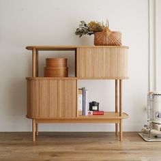 a wooden shelf sitting on top of a hard wood floor next to a white wall