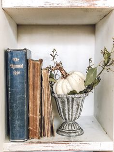 an old book and some pumpkins on a shelf