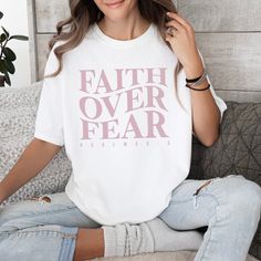 Embrace your faith over fear with this comfortable tee that features the powerful words "Faith Over Fear" and the encouraging message from Psalm 56:3. Let this t-shirt remind you to trust in God and conquer your fears. Perfect for everyday wear or as a faith-based gift for a loved one. Features: 100% USA Cotton Preshrunk Sizing is unisex & true to size. Size up for an oversized fit. Color: White Super cozy & will hold their shape wash after wash.(Machine wash cold & tumble dry Christian Wear, Conquer Your Fears, Psalm 56, Jesus Clothes, T-shirt Print Design, Trust In God, Unique Gifts For Women, Shirt Print Design, Faith Over Fear