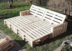 a bed made out of wooden pallets sitting in the grass