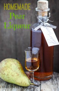 a bottle of pear liqueur next to a glass with a pear in it