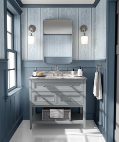 a bathroom with blue walls and white counter tops, along with a large mirror on the wall