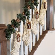 christmas stockings hanging on the banisters with pine cones and evergreen garland attached to them