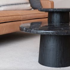 a black marble coffee table sitting in front of a couch