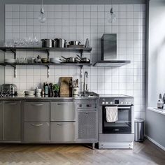 a kitchen with stainless steel appliances and shelves filled with pots, pans, and utensils